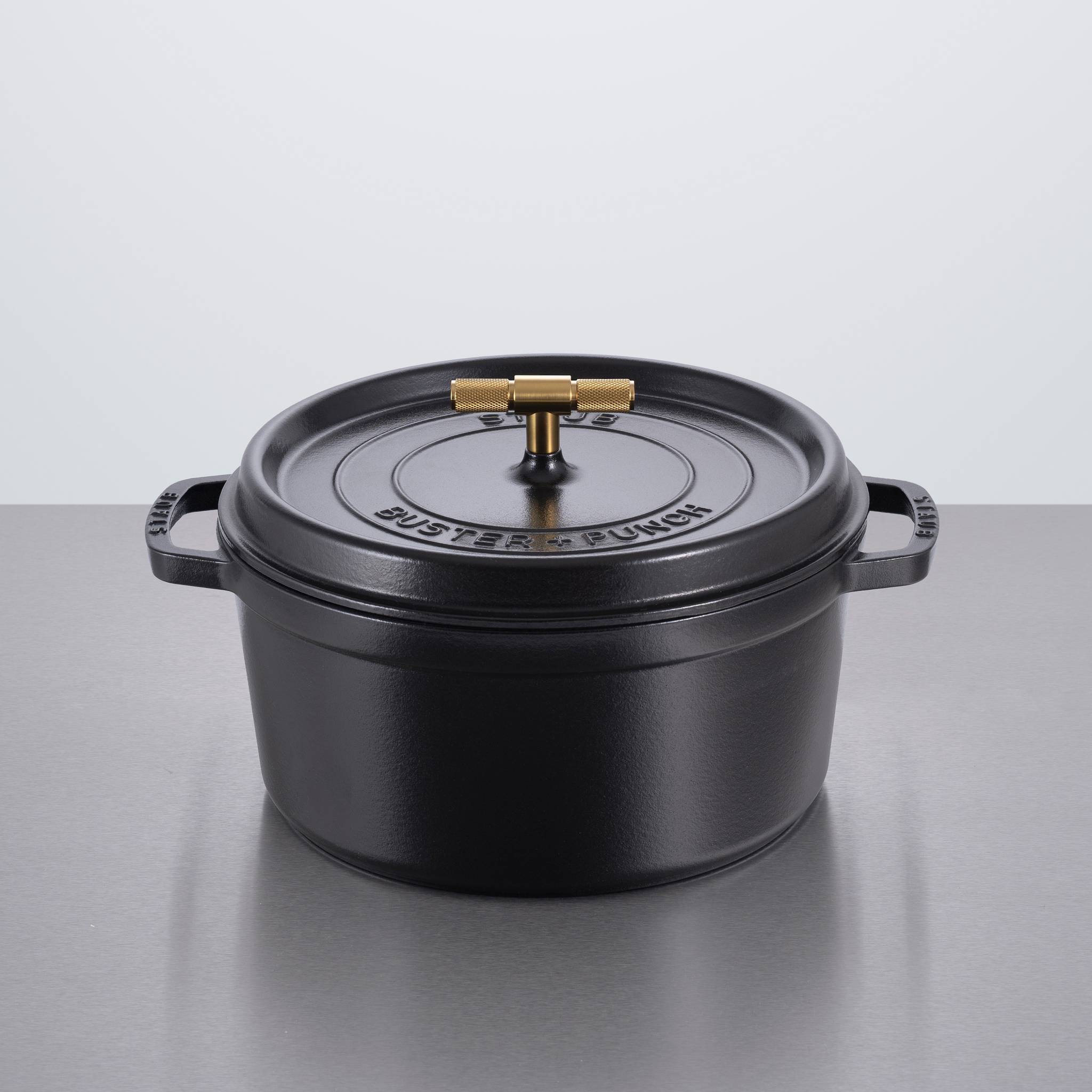 Staub x Buster & Punch | Oală de Gătit din Fontă Emailată 28 cm | Negru | Detaliu Oțel sau Alamă